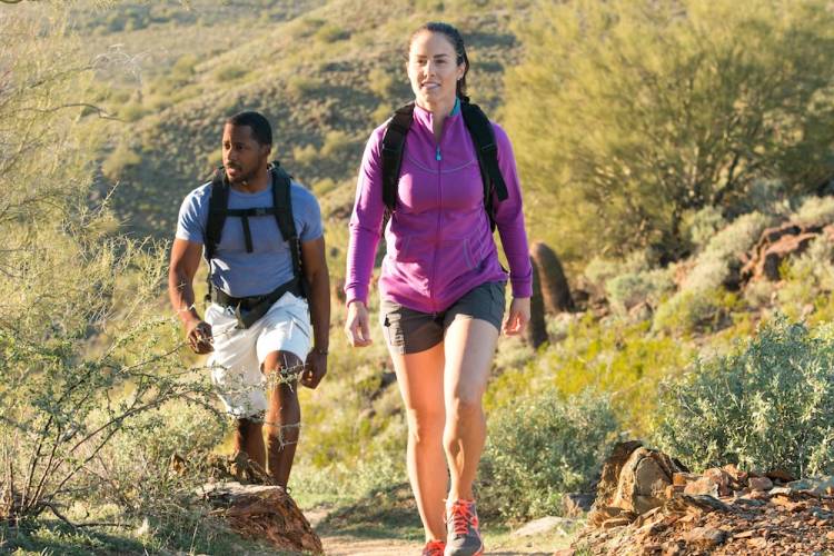 A young couple hiking on a mountainous desert trail