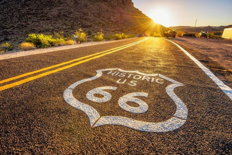 Historic Route 66 emblem on a road at sunset