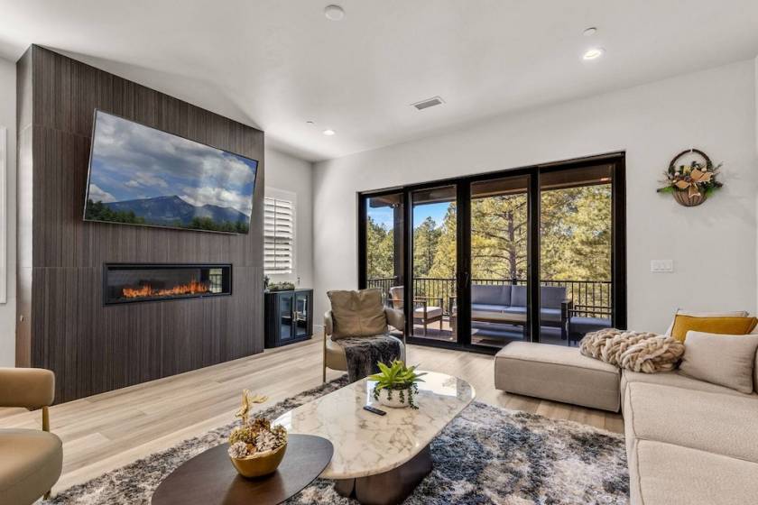 Vacation rental interior with modern furnishing, large flat-screen TV, and fireplace shown.
